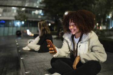 Junge Frauen nutzen nachts ihr Smartphone - WPEF08716