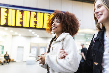 Glückliche junge Freunde zusammen in der Bahnhofshalle - WPEF08735