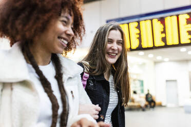 Cheerful young friends together at railroad station lobby - WPEF08736