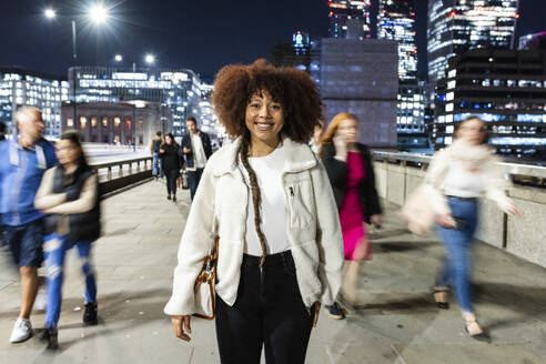 Glückliche junge Frau in der City of London bei Nacht - WPEF08744