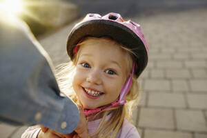 Glückliches Mädchen mit Sporthelm auf dem Fußweg - NSTF00049