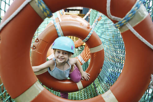 Smiling girl doing obstacle course at rope park - NSTF00061