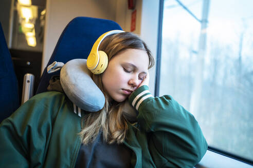 Tired blond girl napping in train - MDOF01939