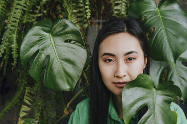 Young woman near monstera leaves - YTF02037