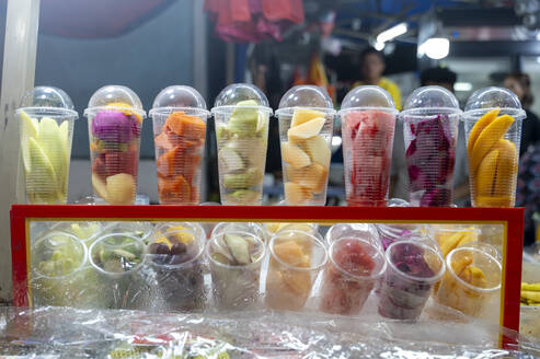 Freshly cut fruit cups on display at a Malaysian market, showcasing vibrant tropical produce. - ADSF53791