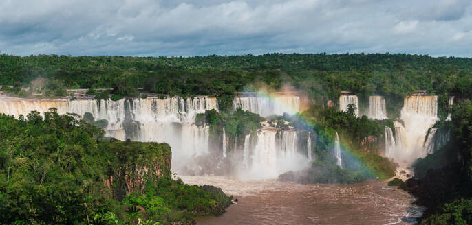 Majestic Iguazu Falls with lush greenery and a vibrant rainbow in Southern Brazil. - ADSF54017