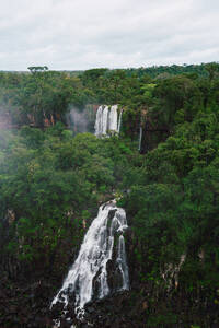 Ein atemberaubender Blick auf die Iguazu-Wasserfälle in Südbrasilien, umrahmt von dichtem Dschungel und bedecktem Himmel. - ADSF54021