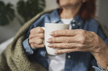 Hands of senior woman holding tea mug - ALKF01060