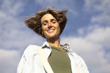Happy woman with eyes closed under sky - OSVF00004