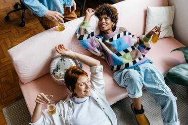 A cozy freelance office setting captures colleagues unwinding on the couch, portraying the blend of relaxation with a working environment. This snapshot of informal coworking represents modern work culture and the growing acceptance of flexible workspaces. - JLPSF31608