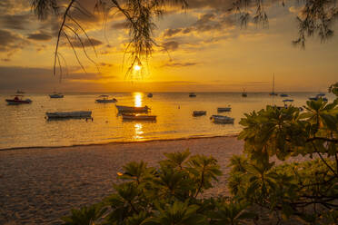 Blick auf Boote am öffentlichen Strand von Mon Choisy bei Sonnenuntergang, Mauritius, Indischer Ozean, Afrika - RHPLF32251