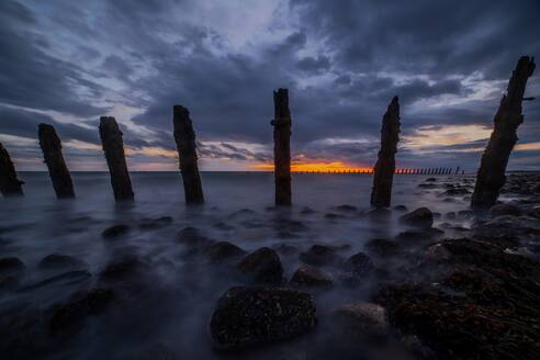 Sturmwolken sammeln sich über der Irischen See, verschlissene Seeverteidigungsanlagen von South Walney bei Sonnenuntergang von der Cumbrian Coast, Cumbria, England, Vereinigtes Königreich, Europa - RHPLF32359