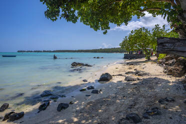 View of man fishing from Mont Choisy Beach and turquoise Indian Ocean on sunny day, Mauritius, Indian Ocean, Africa - RHPLF32423