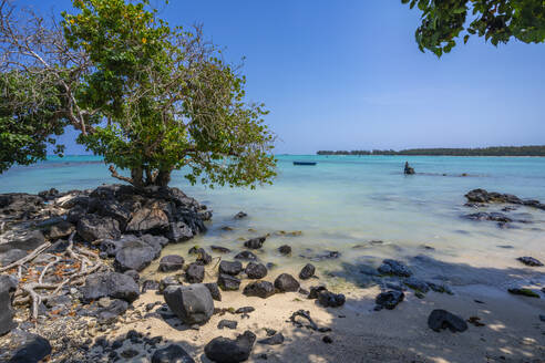 View of man fishing from Mont Choisy Beach and turquoise Indian Ocean on sunny day, Mauritius, Indian Ocean, Africa - RHPLF32434