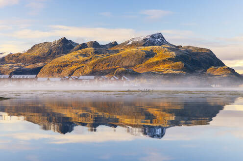 Mountains and rorbuer reflected in a Fjord during sunset, Leknes, Vestvagoy, Nordland, Lofoten Islands, Norway, Scandinavia, Europe - RHPLF32508