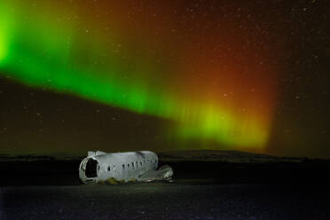 A crashed DC-3 aircraft under the Northern Lights (Aurora Borealis), Iceland, Polar Regions - RHPLF32694