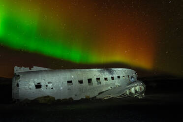 A crashed DC-3 aircraft under the Northern Lights (Aurora Borealis) in Iceland, Polar Regions - RHPLF32697