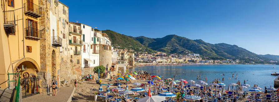 Panoramablick auf Touristen am Strand, Berge im Hintergrund, Cefalu, Provinz Palermo, Sizilien, Italien, Mittelmeer, Europa - RHPLF33068