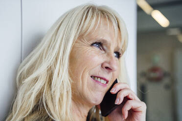 Smiling businesswoman talking on mobile phone - JOSEF23913