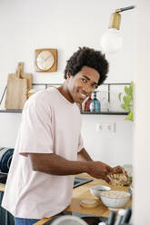 Germany, young man making breakfast - FLMZF00029