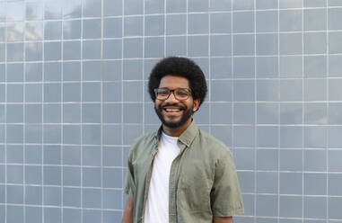 Portugal, young smiling man against the blue tile wall - VRAF00487