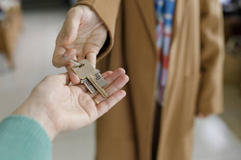UAE, woman's hands handing a key to a new owner - TYF00819