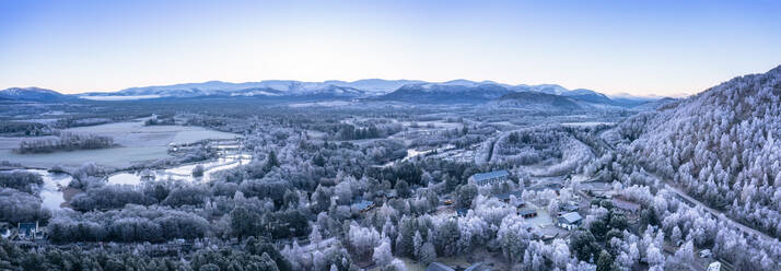 UK, Scotland, Aviemore, Aerial panorama of town in Cairngorm Mountains at winter dawn - SMAF02719