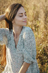 Young woman in field during sunset - ALKF01108