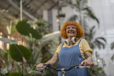 Happy redhead senior woman with bicycle - ALZF00016