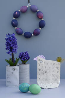 Easter eggs, grape hyacinths in aluminum cans and hen made of wrapping paper - GISF01056