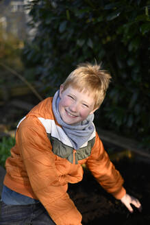 garden, AltesLand, Hamburg, Germany, gardeninglife, spring, springtime, boy, 10years, raised bed, orange, jacket, smile, red hair - GISF01058