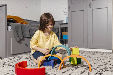 Boy playing in a room with a rainbow-shaped pyramid - ELMF00132