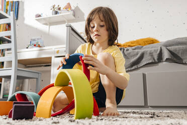 Boy playing in a room with a rainbow-shaped pyramid - ELMF00136