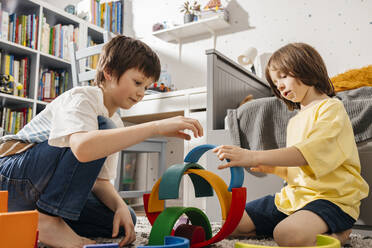 Boys, brothers play in the nursery with a wooden multi-colored rainbow - ELMF00138