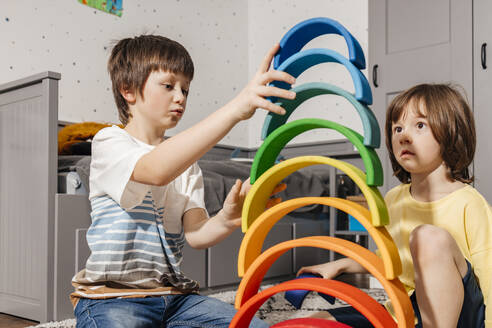 Brüder bauen Pyramide mit buntem Regenbogenspielzeug zu Hause - ELMF00142