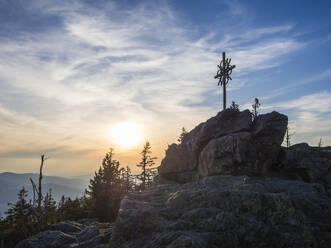 Deutschland, Bayern, Sonnenuntergang über Gipfelkreuz im Bayerischen Wald - HUSF00346