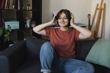girl with headphones on the couch - MCHF00030