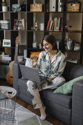 girl in pajamas working at a laptop - MCHF00038