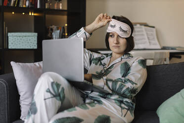 girl in pajamas working at a laptop - MCHF00053