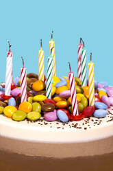 Vibrant still life of chocolate and vanilla birthday cake with colorful toppings and celebration candles - RDTF00081