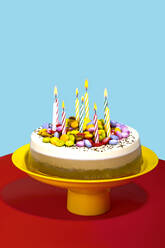 Vibrant still life of chocolate and vanilla birthday cake with colorful toppings and celebration candles - RDTF00087