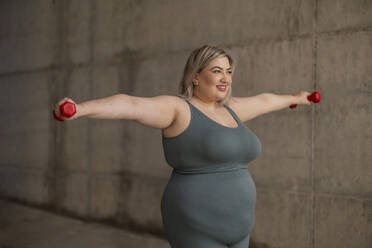 Curvy young adult woman doing sports training outdoors in Juan Carlos I public park. Madrid/Spain - ALZF00068