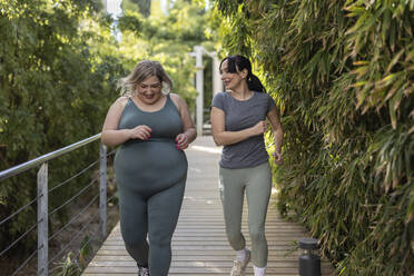 Curvy young adult woman doing sports training outdoors in Juan Carlos I public park. Madrid/Spain - ALZF00074