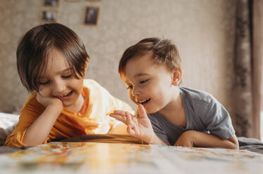 Children are reading a book at home - ANAF02805