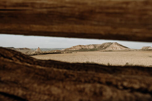 Faszinierende Landschaft der Wüste Bardenas Reales, umrahmt von verwitterten Holzplanken, unter einem klaren Himmel in Navarra, Spanien. - ADSF54033