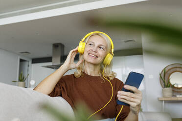 UAE, a woman listening to music at home - TYF00825