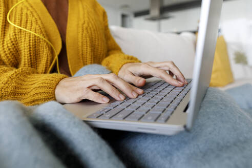 UAE, a woman in a cold apartment working on the laptop - TYF00828