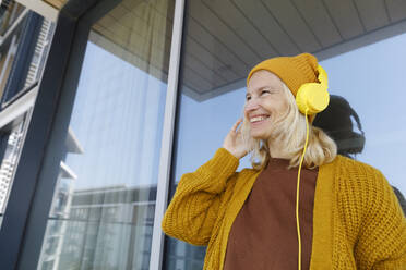 UAE, a woman listening to music on the balcony - TYF00831