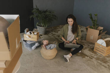 Gdansk, Poland, woman moving to a new place with a lot of boxes and personal belongings and buys new things on the Internet - VIVF01309