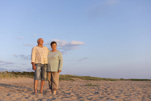 Change of generations. Seed in the second generation. Adults walk along the beach in the setting sun. - OSVF00023